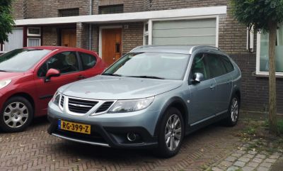 Front three-quarter view of metallic crossover SUV with roof rails and alloy wheels.