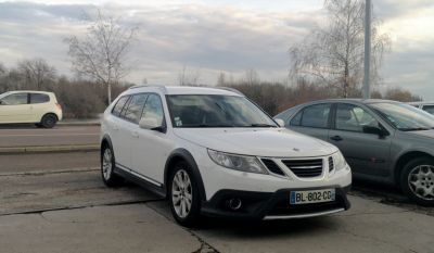 White crossover station wagon front view with grille and roof rails