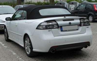 White convertible with black soft top and rear spoiler