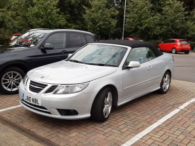 Silver convertible with soft top and front grille