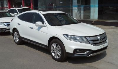 White crossover SUV showing front side view with sleek headlights and alloy wheels