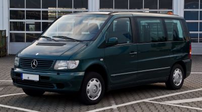 Front side view of vintage minivan with multi-window body and steel wheels