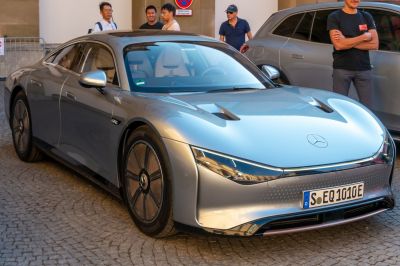 Sleek aerodynamic electric luxury sedan with futuristic front design and distinctive wheels.
