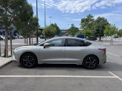 Aerodynamic electric sedan side view with black alloy wheels