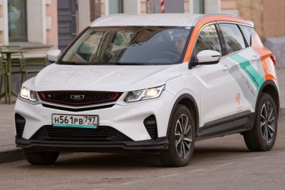 Front view of SUV with black and red grille, sharp headlights lit.
