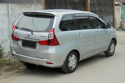 Rear three-quarter view showing roof spoiler and clear tail lights on compact MPV.