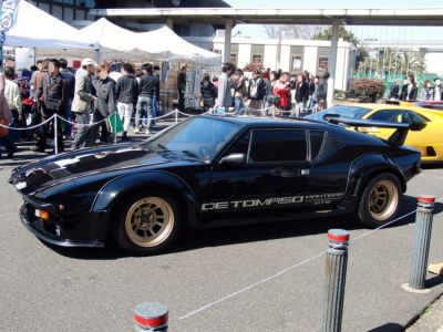 Black widebody sports coupe with rear spoiler and side vents