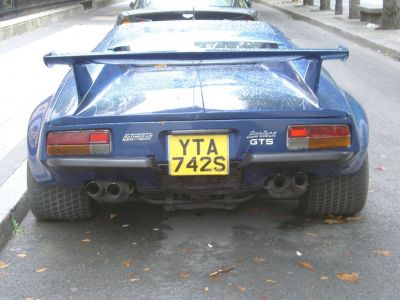 Rear view with wide tires and large spoiler on a vintage sports car.