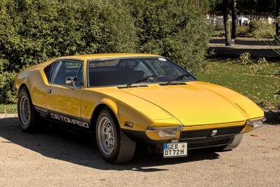 Yellow vintage wedge-shaped sports car with pop-up headlights