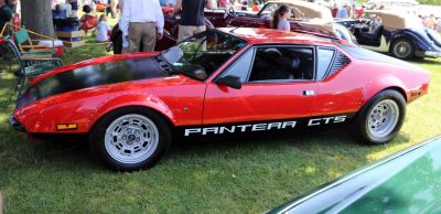 Side profile of vintage sports car with riveted wheel arches and two-tone hood