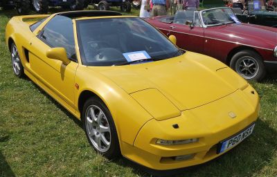 Yellow convertible sports car with pop-up headlights and alloy wheels