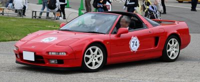 Red convertible sports car with white wheels and racing decals