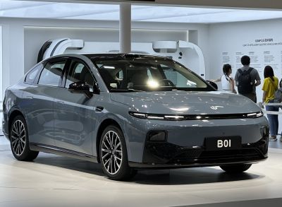 Futuristic electric sedan front with sleek LED headlights and stylish wheels