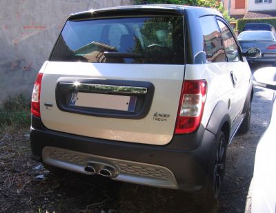 Rear view of compact microcar with dual exhaust and hatchback design