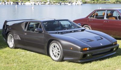 Sleek mid-engine sports car with pop-up headlights and rear wing.