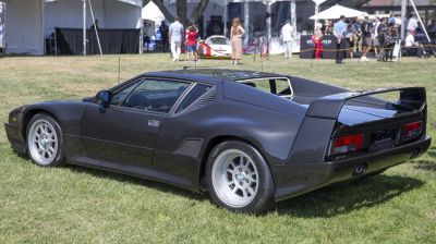 Sleek rear side view with large aerodynamic rear wing and sports wheels.