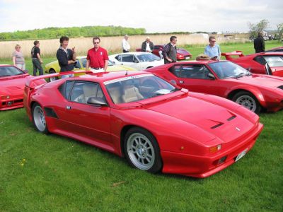 Red sports coupe with rear spoiler and multi-spoke racing wheels