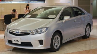 Silver hybrid sedan front side with aerodynamic design and alloy wheels