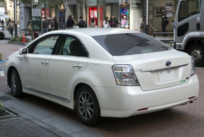 Rear and side view of a hybrid sedan with distinctive rear lights and hybrid badge.