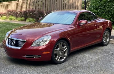 Front and side view of a sleek luxury coupe with distinct headlamps and alloy wheels