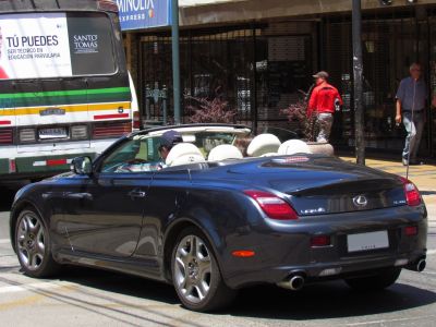 Rear view of black convertible with white leather interior and dual exhausts