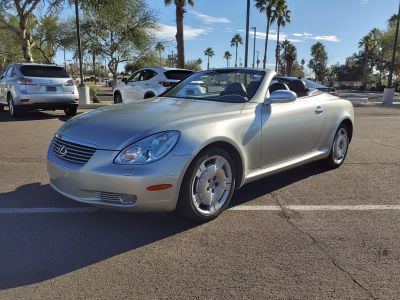 Front view of a silver convertible with distinct headlights and unique alloy wheels.