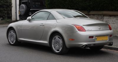 Silver luxury coupe rear side view with dual exhaust and smooth curves