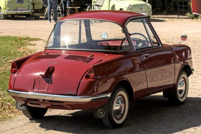 Rear view of vintage compact coupe with round taillights and whitewall tires