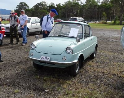 Vintage microcar front view with round headlights and chrome bumper