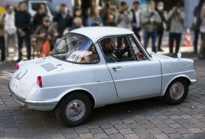 Compact vintage microcar with unique rear styling and round hubcaps