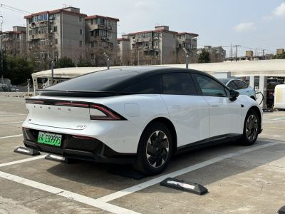 Rear side view of sleek electric sedan with black roof and rear light bar