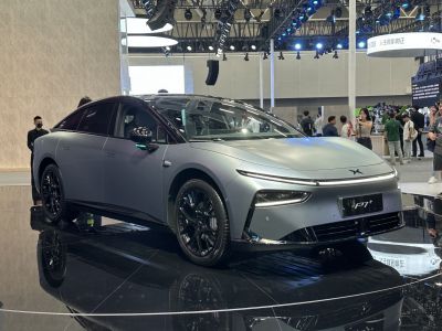Electric sedan with narrow LED headlights and black alloy wheels.