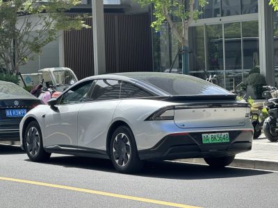 Rear-side view of sleek electric sedan with aerodynamic design and modern rear lights.
