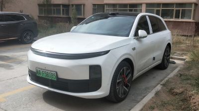 Front side view with sleek LED headlights and black roof.