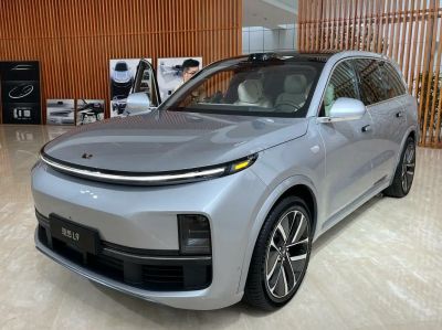 Front angled view of a silver SUV with a continuous LED light strip and modern aerodynamic shape