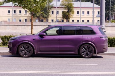 Side view of a sleek purple electric SUV with tinted windows and modern wheels