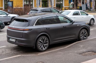 Rear side view of a matte black electric SUV with continuous taillight strip