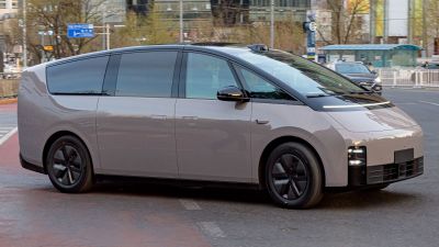 Futuristic EV with seamless window design and LED lights.