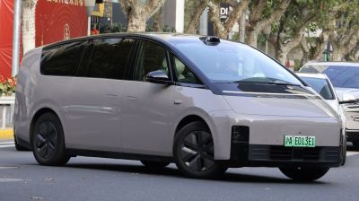 Futuristic electric minivan with sleek design and rooftop sensor array