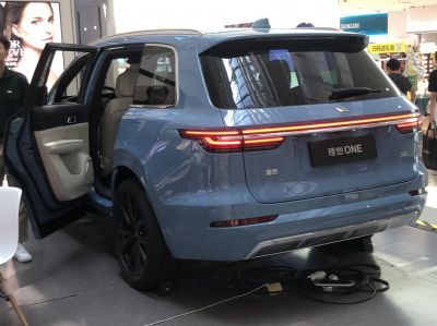 Rear view with LED light bar and open rear door of an electric SUV