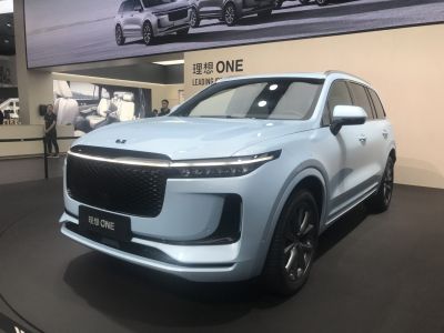 Large grille and LED headlights on white SUV front side