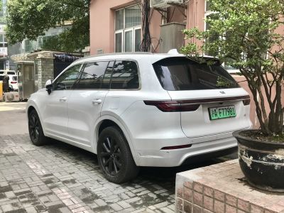 Rear side view of a white modern SUV with sleek taillights and tinted windows
