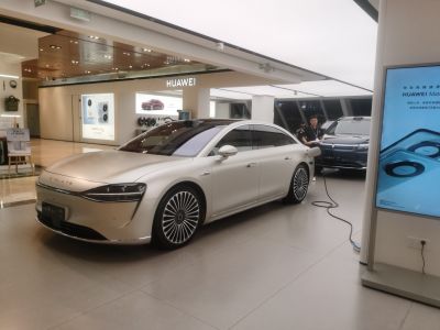 Electric sedan with sleek body design and stylish multi-spoke wheels.