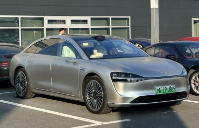 Silver electric sedan with aerodynamic shape and LED headlights