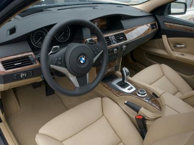 Beige leather seats with wood trim dashboard and advanced control console.