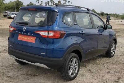 Rear and side view of a blue compact crossover SUV with alloy wheels and roof rails.
