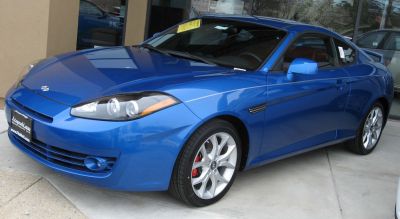 Blue coupe with angular front and sporty alloy wheels