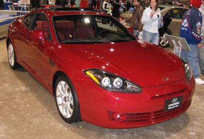 Red sports coupe front with distinctive headlights and smooth aerodynamic shape