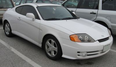 White sporty coupe with distinctive headlights and alloy wheels