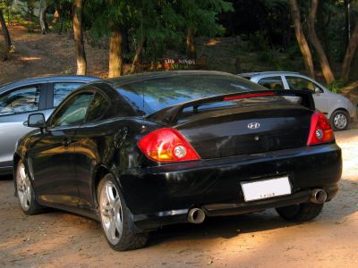 Black sports coupe rear with spoiler and dual exhaust